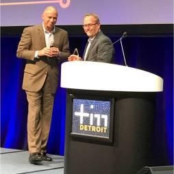 Two men presenting at Detroit podium